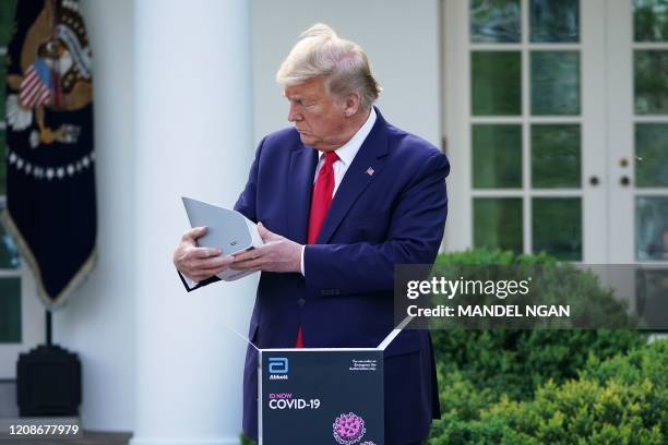 President Donald Trump holds a 5-minute test for COVID-19 from Abbott Laboratories during the daily briefing on the novel coronavirus, COVID-19, in...