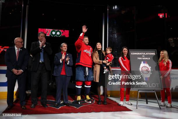 Alex Ovechkin of the Washington Capitals acknowledges the crowd with his son, Sergei Ovechkin, wife Nastya Shubskaya as he is honored for scoring 700...