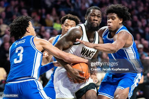 Chaundee Brown of the Wake Forest Demon Deacons is guarded by Tre Jones and Vernon Carey Jr. #1 of the Duke Blue Devils during the first half during...