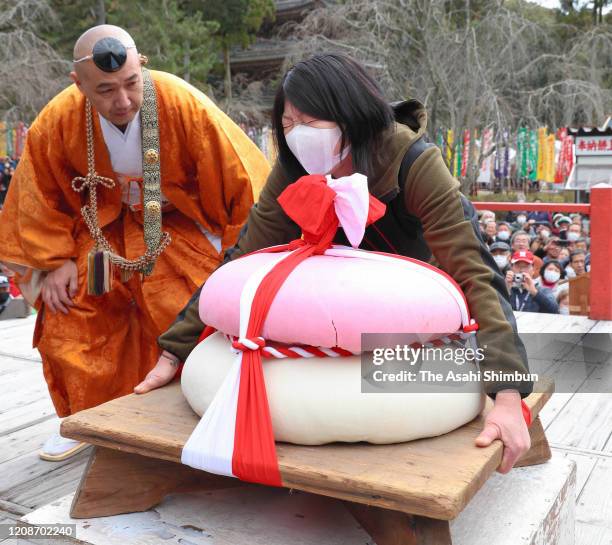 Woman tries to lift a 90-kg "kagami mochi" during the Mochiage Chikara Hono competition at Daigoji temple on February 23, 2020 in Kyoto, Japan. The...