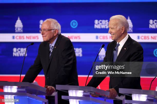 Democratic presidential candidate former Vice President Joe Biden smiles as Sen. Bernie Sanders looks on during the Democratic presidential primary...