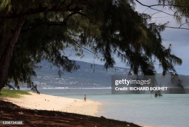 Two person stands on Sain-Gilles de la Reunion beach, on the French overseas department of La Reunion, despite the access at the beaches are...