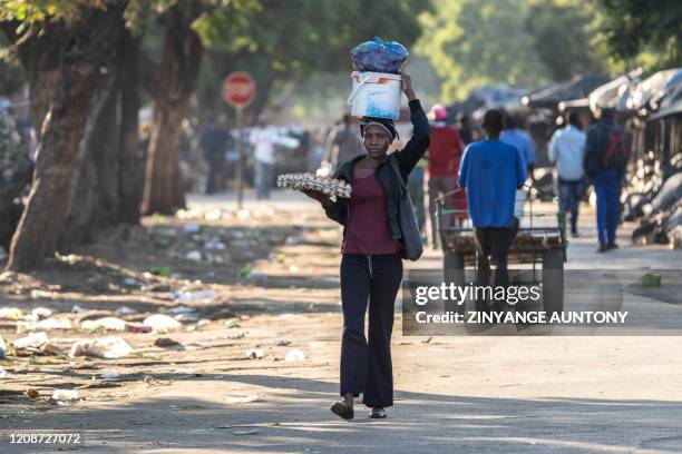 Vendor walks the street after stocking fresh produce from vegetable market in Bulawayo, Zimbabwe on March 31 on the second day of a lockdown directed...