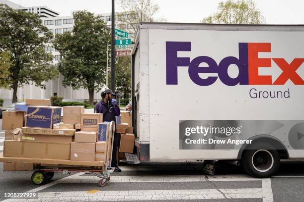 FedEx worker unloads packages from his delivery truck on March 31, 2020 in Washington, DC. To prevent the spread of COVID-19, Virginia, Maryland and...