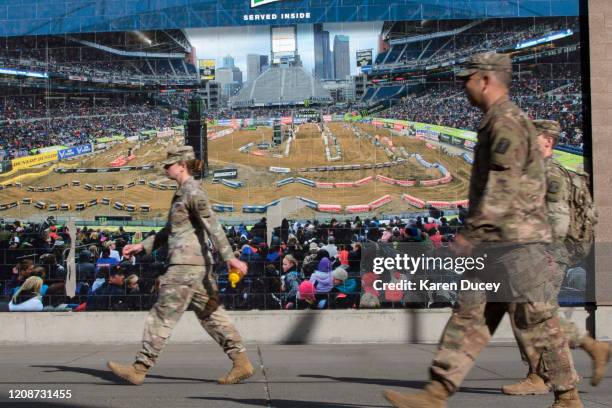 Military personnel walk past a mural outside the 627th Hospital Center field hospital at CenturyLink Event Center on March 31, 2020 in Seattle,...