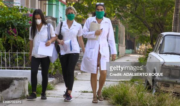 Cuban doctor Liz Caballero , from El Vedado polyclinic in Havana, walks with two students as they go door by door looking for possible cases of the...