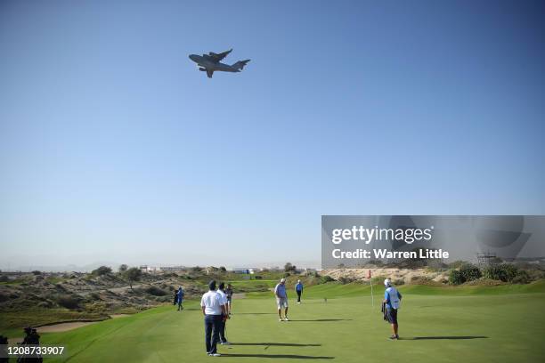 Paul Lawrie of Scotland plays in the pro am as a C-17 Globemaster III takes off ahead of the Oman Open at Al Mouj Golf on February 26, 2020 in...