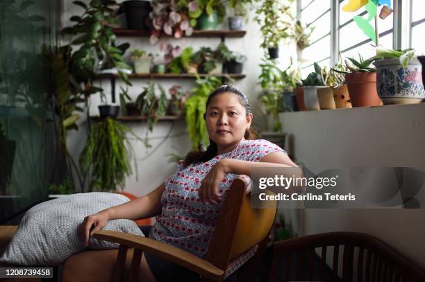 portrait of a woman in her living room - showus portrait stock pictures, royalty-free photos & images