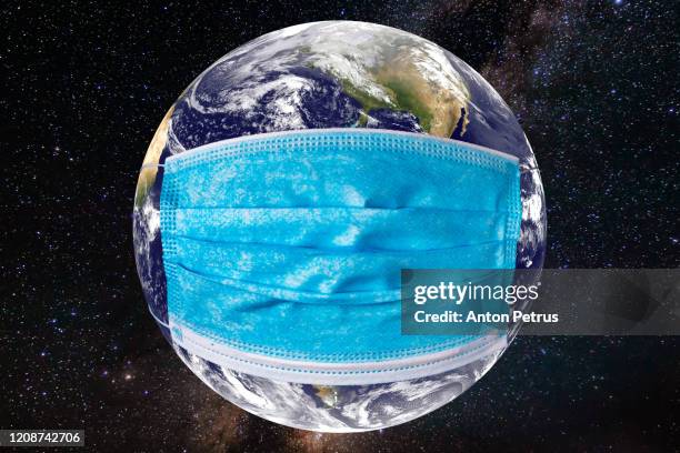 planet earth with a medical mask. world epidemic concept - venedig gondel stock-fotos und bilder