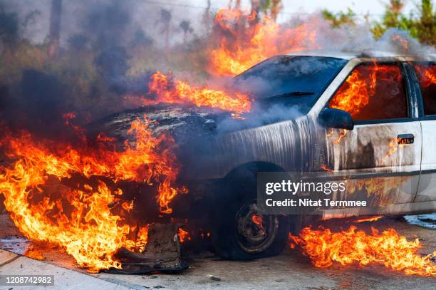 close-up of burning car after a frontal crash collision on the roadside with flame and smoke. - car engine close up stock pictures, royalty-free photos & images