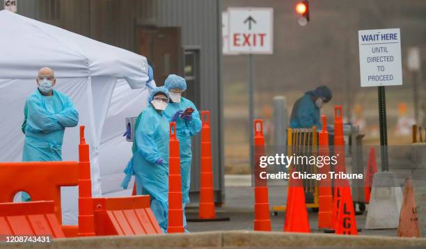 Medical personnel at Advocate Lutheran General Hospital in Park Ridge, Ill. Wait for patients as they conduct drive-thru COVID-19 testing on March...