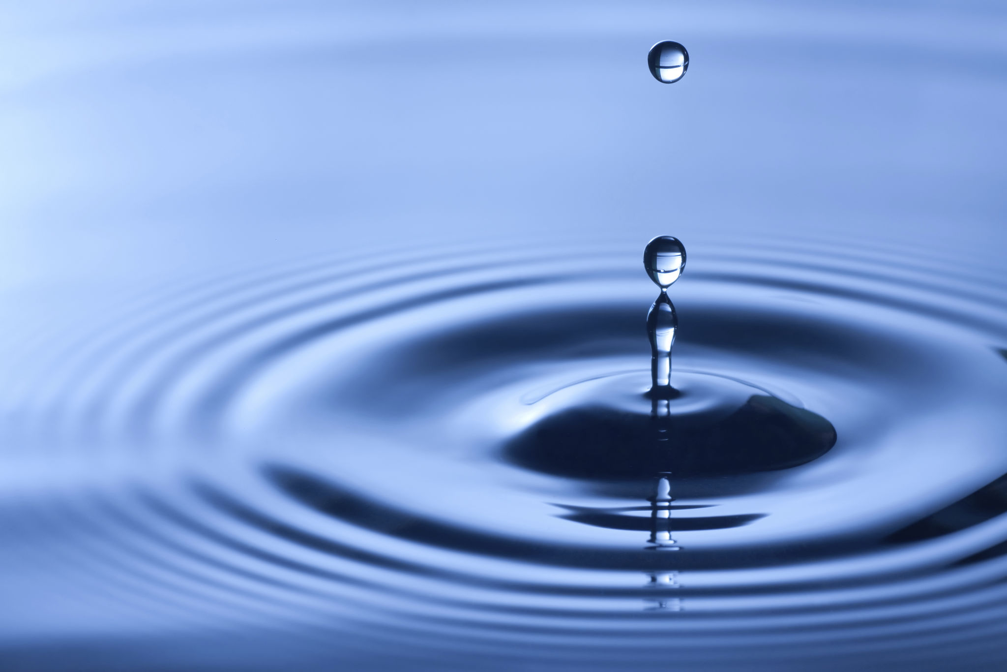 Close-up shot of water drop in dark blue shade Close-up shot of water drop in dark blue shade