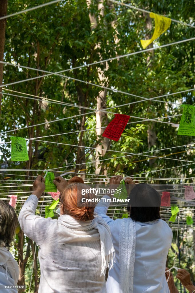 Tying sacred threads during Buddhist ceremony.