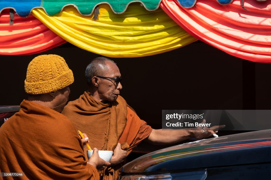 Monk blessing a truck.