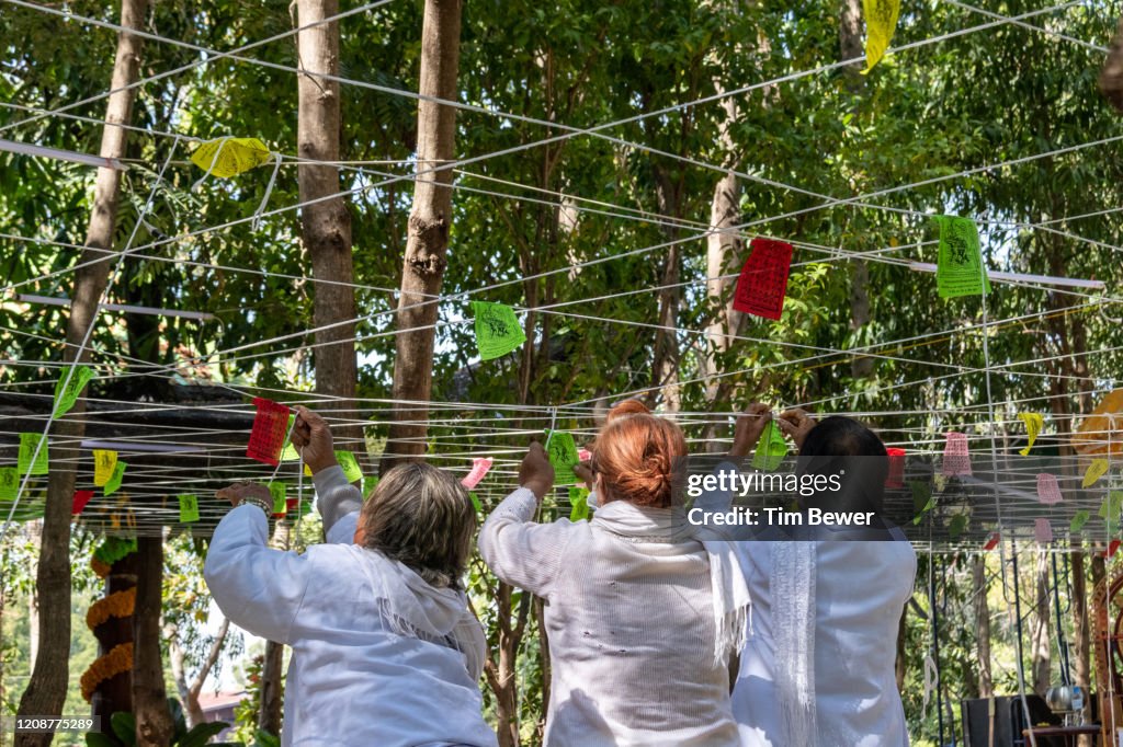 Tying sacred threads during Buddhist ceremony.
