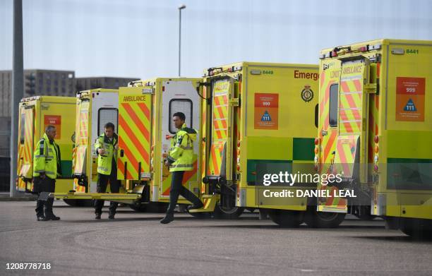 London Ambulance staff members are seen with vehicles in the car park at the ExCeL London exhibition centre in London on April 1 which has been...