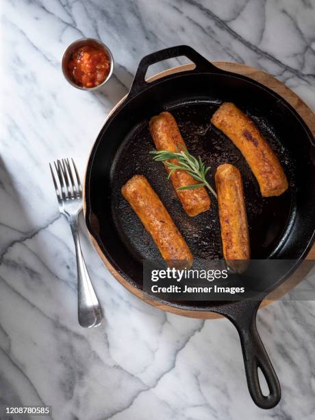 vegan sausages on a white marble table. - vegan sausage stock pictures, royalty-free photos & images
