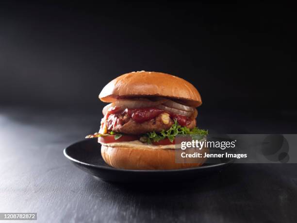 vegan burger on a black plate. - dark bread stock pictures, royalty-free photos & images