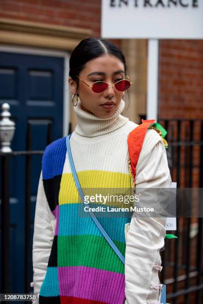 Guest wearing block colour knitted jumper attends JW Anderson during London Fashion Week February 2020 on February 17, 2020 in London, England.