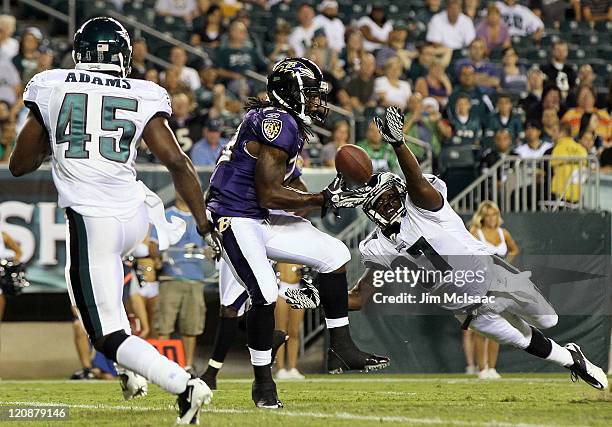 Damien Berry of the Baltimore Ravens can't hold onto the ball in the endzone as Jamar Wall and Jamar Adams of the Philadelphia Eagles defend during a...