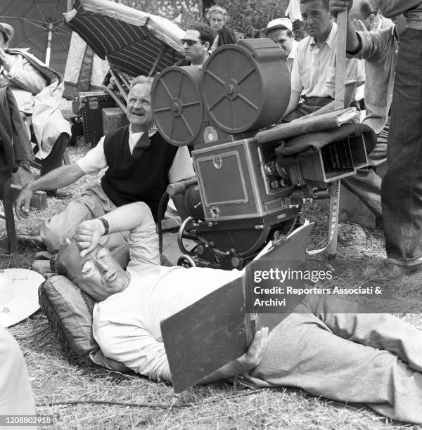Italian director Mario Camerini lying on the straw and reading the script on the set of the film Ulysses. 1953