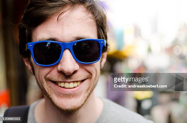 male portrait wearing blue sunglasses - andreaskoeberl stock-fotos und bilder