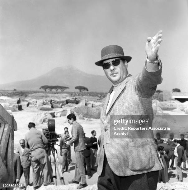 Italian director Roberto Rossellini working on the set of his film "Journey to Italy". His raising his arm and pointing out something far. 1953