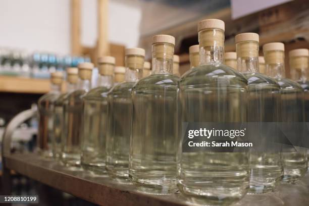 gin bottles with stoppers in production - licores de alta graduación fotografías e imágenes de stock