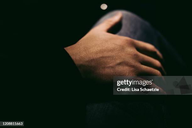 man puts his hand on a woman's thigh by night - uomo donna per mano foto e immagini stock