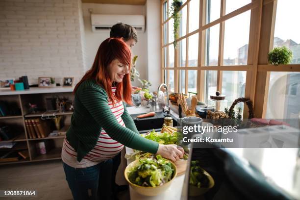 mooi paar dat gezonde lunch samen in hun moderne keuken maakt - romaine stockfoto's en -beelden