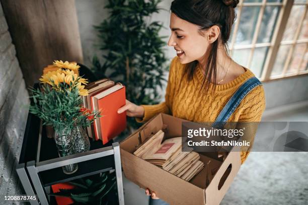 donne che organizzano cose in un nuovo appartamento - arrangiare foto e immagini stock