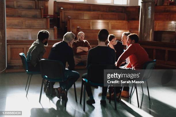 group of men, seated in therapy session - alternative therapy stock pictures, royalty-free photos & images