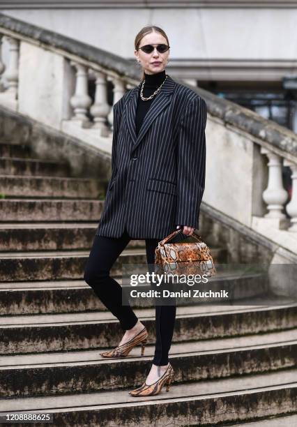 Pernille Teisbaek is seen wearing a Margiela jacket, and snakeskin bag and heels outside the Maison Margiela show during Paris Fashion Week: AW20 on...