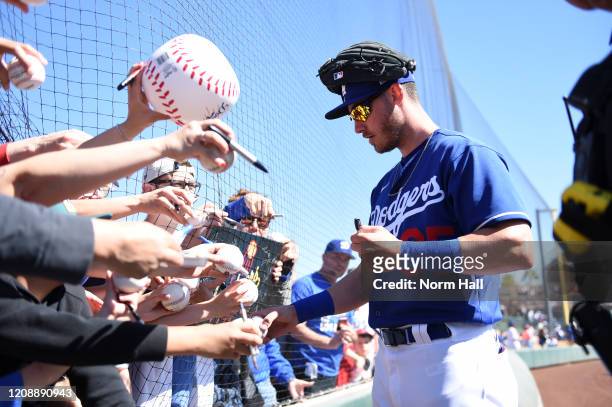 Cody Bellinger of the Los Angeles Dodgers signs autographs prior to a spring training game against the Los Angeles Angels at Camelback Ranch on...