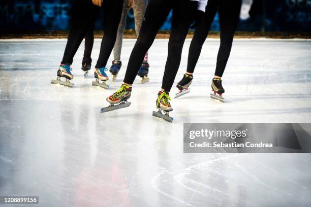 children, winter sport and leisure concept - close up of legs in speed skates on  skating rink, leader  in training lessons. - capo leader foto e immagini stock