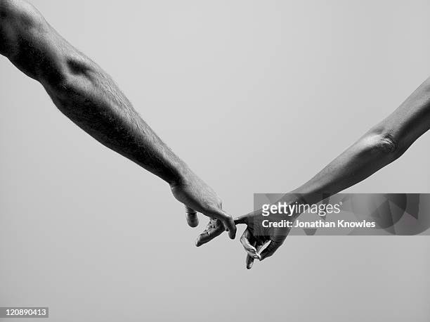 female and male connecting by fingers - darsi la mano foto e immagini stock
