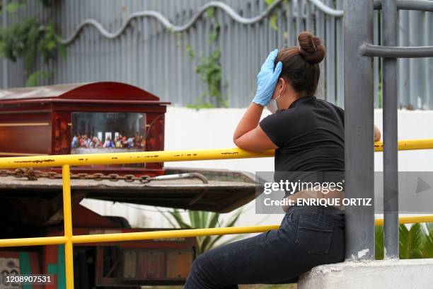 Woman wearing a face mask and gloves mourns as she waits for the corpse of a relative outside a hospital in Guayaquil, Ecuador on April 1, 2020. -...