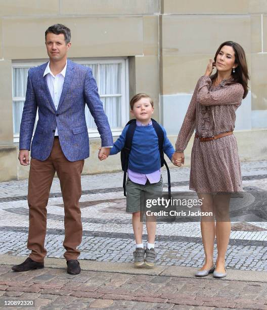 Crown Prince Frederik of Denmark and Crown Princess Mary of Denmark pose for photographs with their son Prince Christian of Denmark on his first day...