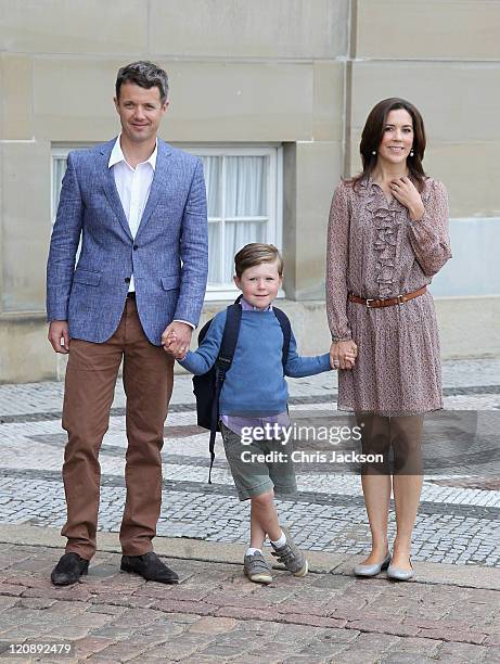 Crown Prince Frederik of Denmark and Crown Princess Mary of Denmark pose for photographs with their son Prince Christian of Denmark on his first day...