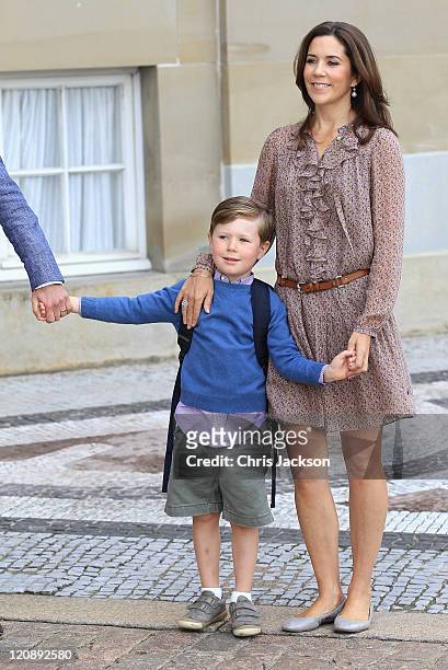 Crown Prince Frederik of Denmark and Crown Princess Mary of Denmark pose for photographs with their son Prince Christian of Denmark on his first day...