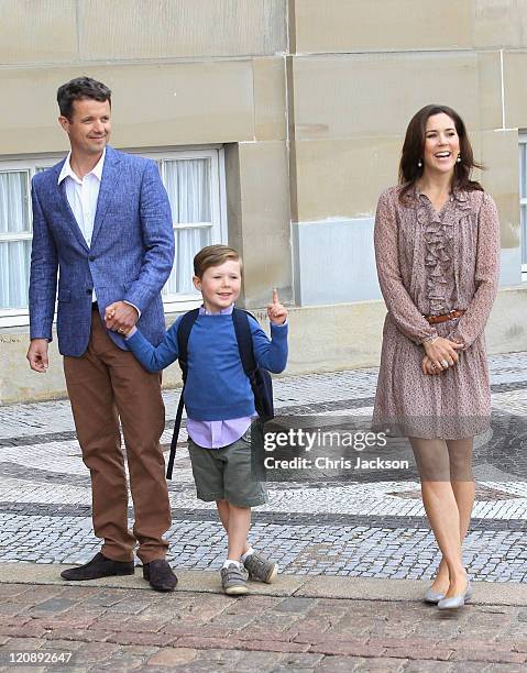 Crown Prince Frederik of Denmark and Crown Princess Mary of Denmark pose for photographs with their son Prince Christian of Denmark on his first day...