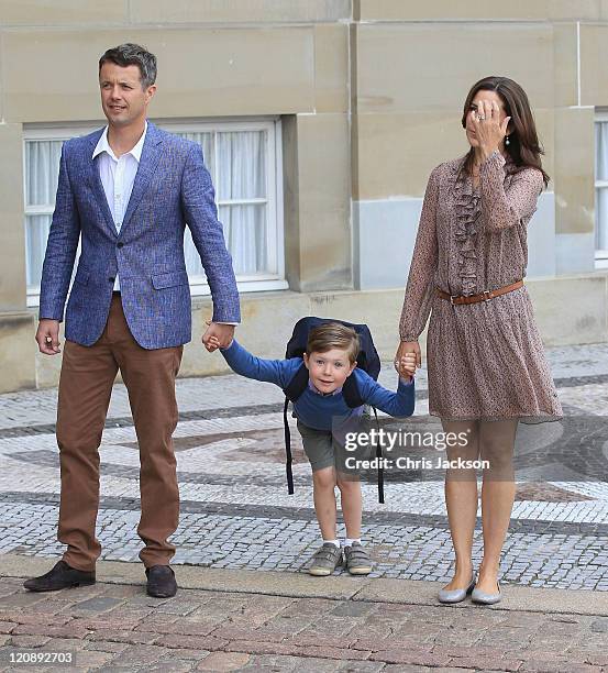 Crown Prince Frederik of Denmark and Crown Princess Mary of Denmark pose for photographs with their son Prince Christian of Denmark on his first day...