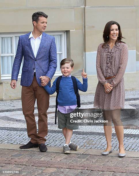 Crown Prince Frederik of Denmark and Crown Princess Mary of Denmark pose for photographs with their son Prince Christian of Denmark on his first day...