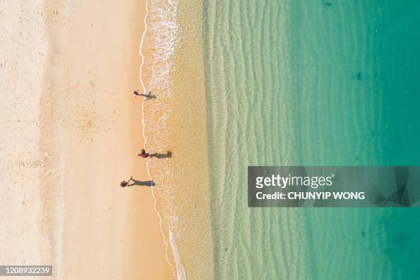 aerial view of turquoise ocean wave reaching the coastline - people aerial view beach stock pictures, royalty-free photos & images