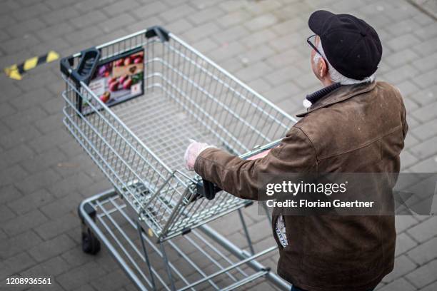 Man with his shopping trolley waits in front of a supermarket on April 02, 2020 in Goerlitz, Germany. As a cause of the corona virus there are...