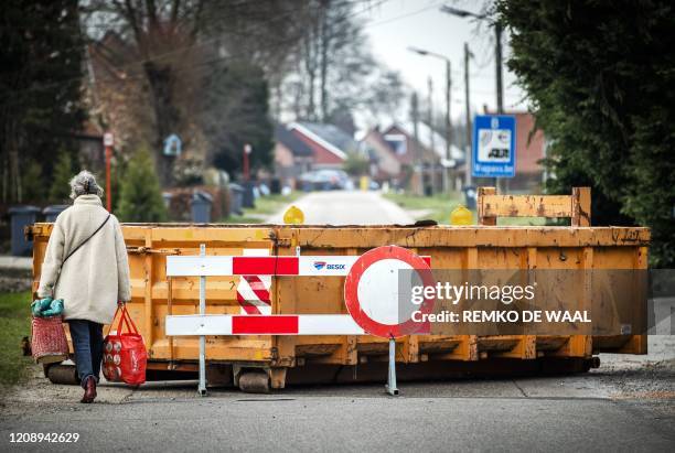 Woman walks past a barrier as the border crossing between the Belgian Meerle and Grazen in the Netherlands is closed on April 2 due to the novel...