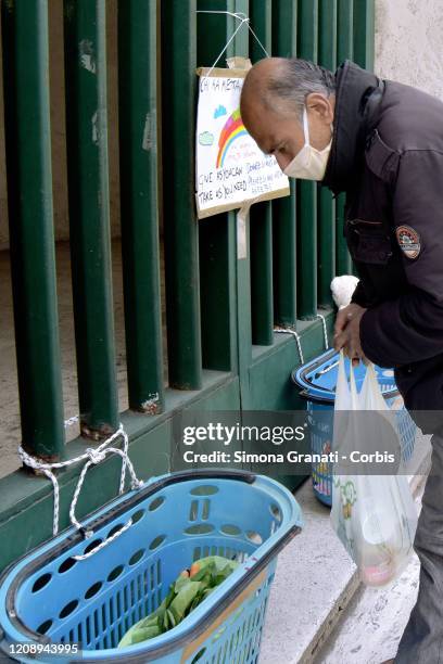 Migrant man takes food at the Collection point for food, toys and basic necessities in the Carlo Pisacane primary school in the multi-ethnic district...