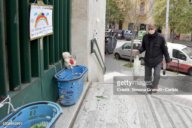 Migrant man takes food at the Collection point for food, toys and basic necessities in the Carlo Pisacane primary school in the multi-ethnic district...