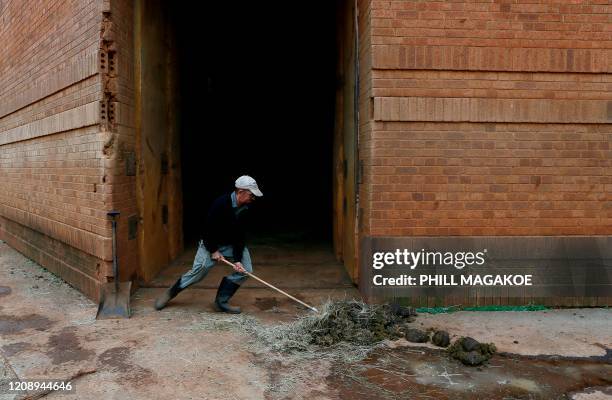 Zookeeper sweeps elephant dung at the National Zoological Gardens of South Africa in Pretoria on April 2 that is closed off to the general public as...