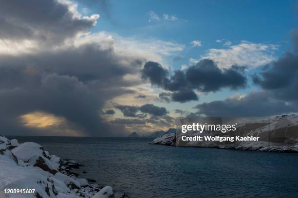 Winter scene with the view of the Norwegian Sea and snow covered mountains near Henningsvaer, a small fishing village near Svolvaer, in the Lofoten...